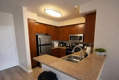 a kitchen with wooden cabinets and a stainless steel refrigerator at Marina Modern 2BR 2BA in Los Angeles
