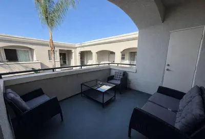 a balcony with couches and a table and a palm tree at Boardwalk & Marina Retreat in Los Angeles