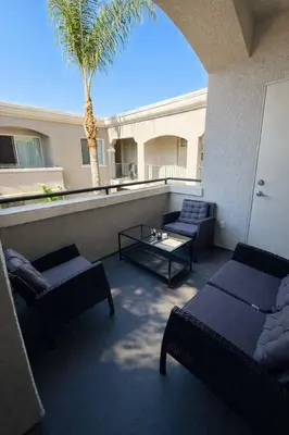 a balcony with couches and a table and a palm tree at Marina del Rey Spacious 2BR 2BA - Venice Beach Minutes Away in Los Angeles