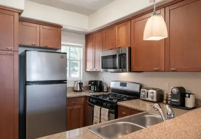a kitchen with wooden cabinets and a stainless steel refrigerator at Marina del Rey Prime 2BR-2BA Location Near Venice Beach in Los Angeles