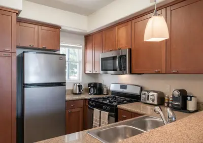 a kitchen with wooden cabinets and a stainless steel refrigerator at Marina del Rey Prime Location & Venice in Los Angeles