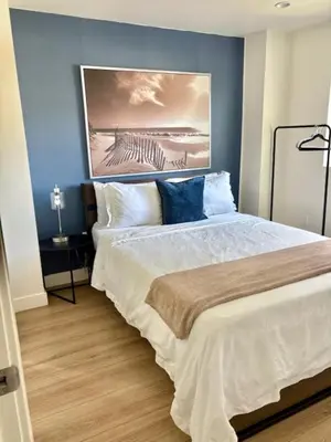 a bedroom with a bed with a painting on the wall at Modern 3Bedroom 3Bath Townhouse in Sherman Oaks