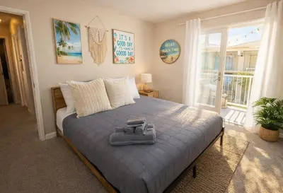 a bedroom with a bed with a blue blanket and a window at Marina del Rey 2BR-2BA Near Venice Boardwalk in Los Angeles