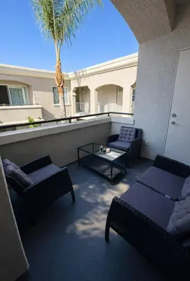 a balcony with couches and a table and a palm tree at Marina del Rey Retreat 2BR--2BA & Close To Venice Beach in Los Angeles