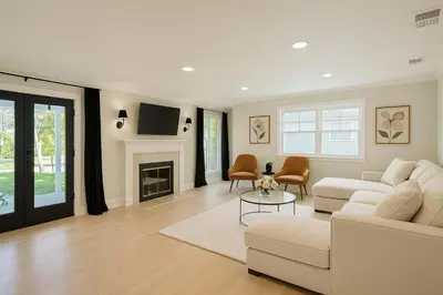 a living room with a white couch and a fireplace at Altadena Retreat Near Rose Bowl and Pasadena in Altadena