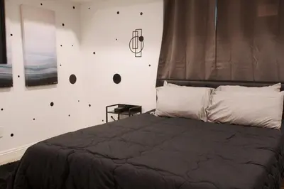 a bedroom with a bed and a wall with holes at Noir and Gold Retreat in Los Angeles