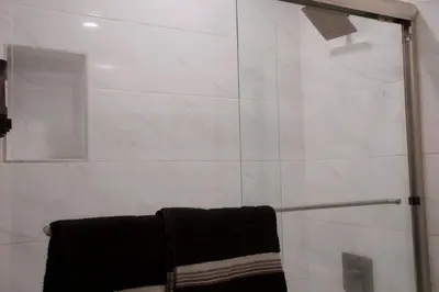 a bathroom with a shower with a black towel at Noir and Gold Retreat in Los Angeles