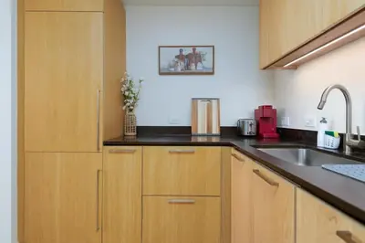 a kitchen with wooden cabinets and a sink at 2Bed Apt View of Hollywood Sign & Rooftop Pool in Los Angeles
