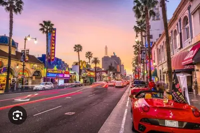 a red car parked on the side of a city street at 2Bed Apt View of Hollywood Sign & Rooftop Pool in Los Angeles