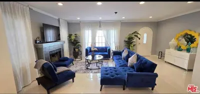 a living room with blue couches and a fireplace at Residents inn in Los Angeles