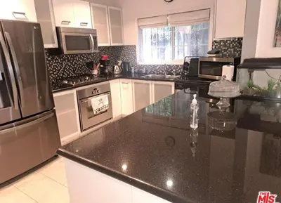 a kitchen with a black counter top and appliances at Residents inn in Los Angeles