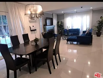 a dining room and living room with a table and chairs at Residents inn in Los Angeles