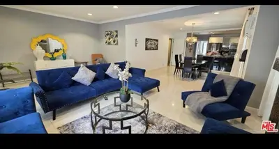 a living room with blue couches and a glass table at Residents inn in Los Angeles