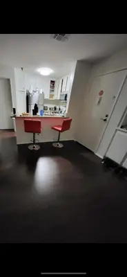 an empty kitchen with two red chairs in a room at Bunk bed spot available, Central LA in Los Angeles