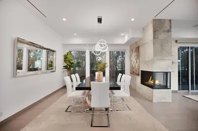 a dining room with a table and chairs and a fireplace at Colgate Vantage in Los Angeles
