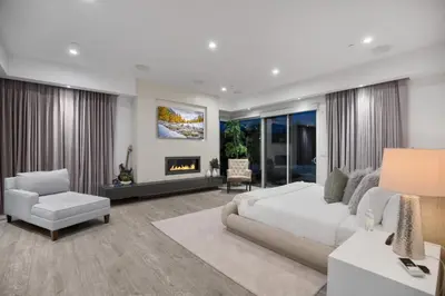 a bedroom with a white bed and a fireplace at Colgate Vantage in Los Angeles
