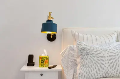 a bed with a blue lamp next to a side table at NEW Venice Rose Ave Retreat with Sunset Deck in Los Angeles