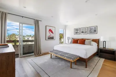 a bedroom with a large bed and a large window at Pacific Breeze - Modern Venice Beach Home in Los Angeles