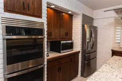a kitchen with wooden cabinets and stainless steel appliances at Sunset villa in Los Angeles
