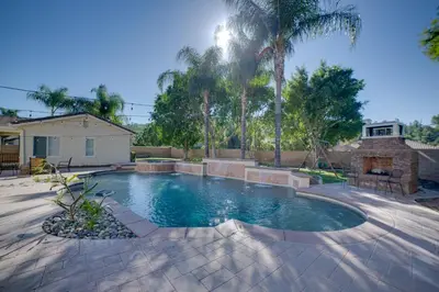 a swimming pool in a yard with palm trees at Resort-Style Oasis Expansive Riverside Mansion in Riverside