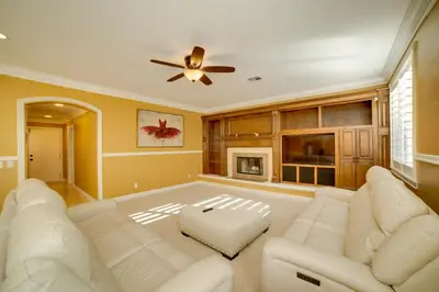 a living room with white furniture and a ceiling fan at Resort-Style Oasis Expansive Riverside Mansion in Riverside