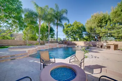 a patio with a swimming pool with chairs and a hot tub at Resort-Style Oasis Expansive Riverside Mansion in Riverside