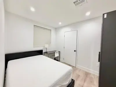 a white bedroom with a bed and a window at 1622 Palm Terrace in Los Angeles