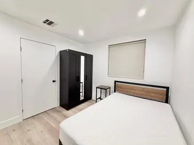 a bedroom with a white bed and a black cabinet at 1622 Palm Terrace in Los Angeles