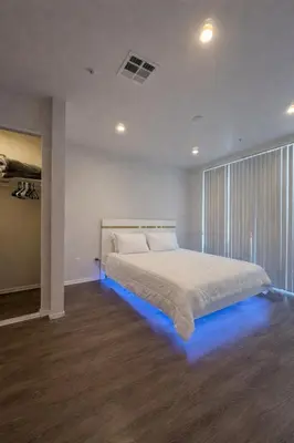 a bedroom with a large bed with blue lighting at Penthouse Escape Pool Views in Glendale