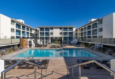 a large swimming pool with chairs and buildings at Drift & Dream - Opulent 1BR Marina Escape in Los Angeles