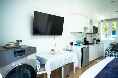 a kitchen with a table and a tv on the wall at Beach House by LA Coast in Torrance