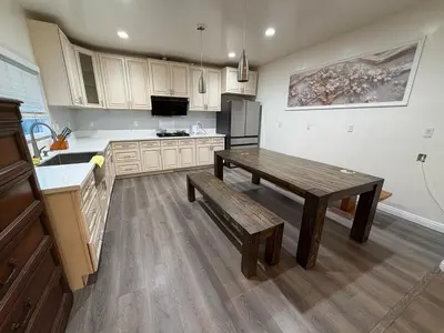 a kitchen with a wooden table and a bench in it at Cozy 2-Bedroom Retreat Home in East Los Angeles in Hacienda Heights