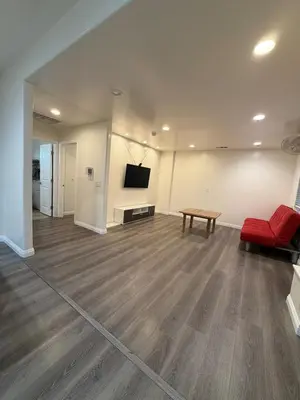 a living room with a red couch and a table at Cozy 2-Bedroom Retreat Home in East Los Angeles in Hacienda Heights