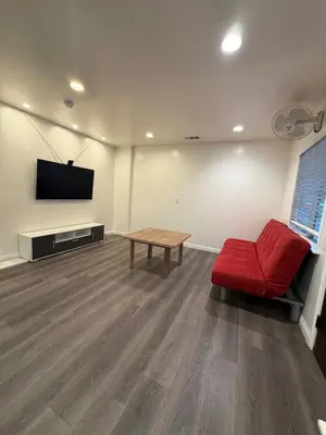 a living room with a red chair and a television at Cozy 2-Bedroom Retreat Home in East Los Angeles in Hacienda Heights