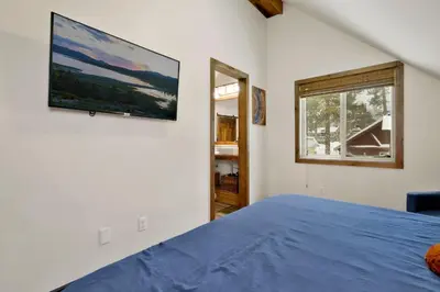 a bedroom with a bed and a tv on the wall at Ursa Major Lodge | Walk to Lake & Village | Pet Friendly Retreat in Big Bear Lake