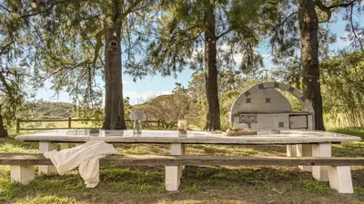 a picnic table in front of a pizza oven at The Malibu Ranch Retreat by AvanStay Malibu Escape • Valley Views Near Zuma The Ranch Malibu in Malibu