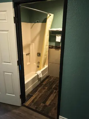 a bathroom with a tub and a shower with a mirror at Highland Park Motel in Los Angeles