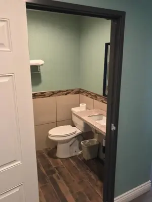 a bathroom with a toilet and a sink and a mirror at Highland Park Motel in Los Angeles
