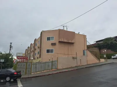 a brown building on the side of a street at Highland Park Motel in Los Angeles
