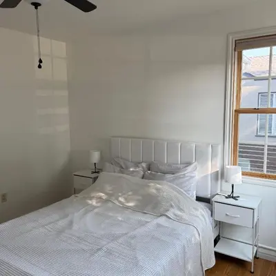 a white bedroom with a bed and a window at Cozy House in Hewitt