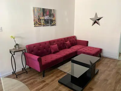 a red couch in a living room with a star on the wall at Charming 1 bedroom apt in Beverly Hills in Los Angeles