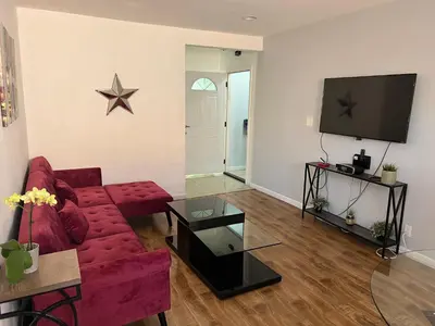 a living room with a red couch and a tv at Charming 1 bedroom apt in Beverly Hills in Los Angeles