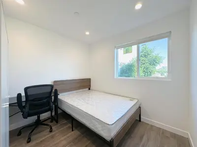 a bedroom with a bed and a desk and a chair at Eiven Homestay in Los Angeles