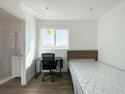 a bedroom with a bed and a desk and a chair at Eiven Homestay in Los Angeles