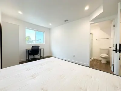 a white room with a bed and a chair in it at The 1443 in Los Angeles