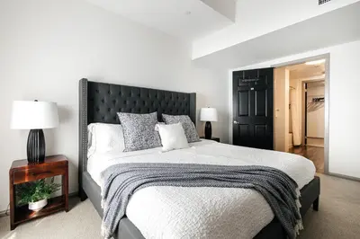 a bedroom with a large bed with a black headboard at Brilliant 2BD condo in Los Angeles