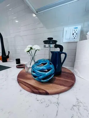 a counter top with a coffee pot and flowers on a cutting board at The Central Apartment at Hollywood in Los Angeles