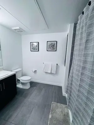 a white bathroom with a shower and a toilet at The Central Apartment at Hollywood in Los Angeles