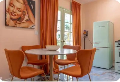 a dining room with a table and orange chairs at Zen guess house in Los Angeles