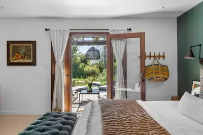 a bedroom with a bed and a door to a patio at Private Estate with Cottage, Pool & Tennis in Ojai